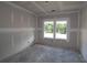 Unfinished bedroom with drywall and concrete floors, featuring two windows at 206 Wild Ginger Bend, Woodstock, GA 30188