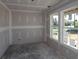 Unfinished bedroom with drywall and concrete floors, featuring two windows and natural light at 206 Wild Ginger Bend, Woodstock, GA 30188