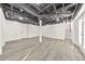 The finished basement has exposed ceiling and gray wood floors and a door to the exterior at 2419 Edgewater Sw Dr, Atlanta, GA 30311