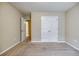 Spacious carpeted bedroom with neutral walls and multiple doors leading into other rooms at 453 Tara Commons Cir, Loganville, GA 30052