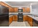 Functional kitchen featuring wood cabinets, black appliances, and easy-to-clean tile flooring at 453 Tara Commons Cir, Loganville, GA 30052