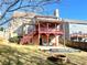 Spacious backyard with a covered deck, patio area, fire pit, and lush greenery for outdoor enjoyment at 929 Bexhill Dr, Lawrenceville, GA 30043