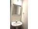 Cozy half bathroom with a pedestal sink, mirror, and towel rack at 929 Bexhill Dr, Lawrenceville, GA 30043