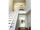 Bright foyer with hardwood floors, white staircase, and view into a dining room with a ceiling fan at 929 Bexhill Dr, Lawrenceville, GA 30043