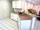 Bright kitchen featuring white cabinets, granite countertops, tile flooring, stainless steel sink, and eat-in bar at 929 Bexhill Dr, Lawrenceville, GA 30043