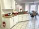 Bright kitchen featuring white cabinets, granite countertops, tile flooring, and a breakfast nook at 929 Bexhill Dr, Lawrenceville, GA 30043