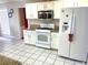Spacious kitchen featuring white cabinets, granite countertops, stainless steel appliances, and tile flooring at 929 Bexhill Dr, Lawrenceville, GA 30043