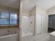 Bathroom featuring a soaking tub, standalone shower, and tiled floors at 983 Noble Oak Ct, Lawrenceville, GA 30046