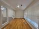 Bright living room with hardwood floors, many windows, and view into another carpeted living space at 983 Noble Oak Ct, Lawrenceville, GA 30046