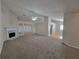Open living room with a fireplace and large windows, seamlessly connecting to the dining area with hardwood floors at 983 Noble Oak Ct, Lawrenceville, GA 30046