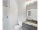 Bathroom with a walk-in shower, white tiled walls, gray vanity, and a toilet at 3139 Stonegate Sw Dr, Atlanta, GA 30331