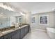 Bathroom boasts dual sinks, a long granite countertop, tiled floors, a soaking tub, and a glass-enclosed shower at 3139 Stonegate Sw Dr, Atlanta, GA 30331