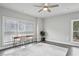 Well-lit bedroom with an area rug, ceiling fan, a built-in desk, and a large window at 3139 Stonegate Sw Dr, Atlanta, GA 30331