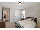 Well-lit bedroom with a bed, side table, and direct access to the hallway at 8605 Gladden Ln, Suwanee, GA 30024