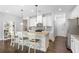 Modern kitchen with white cabinets, granite countertops, stainless steel appliances, and a breakfast bar at 8605 Gladden Ln, Suwanee, GA 30024