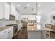 Well-lit kitchen with an island, stainless steel appliances, granite countertops, and dark hardwood floors at 8605 Gladden Ln, Suwanee, GA 30024