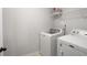 Bright laundry room features a washing machine, dryer, and white wire rack shelf for storage at 8605 Gladden Ln, Suwanee, GA 30024