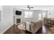 Bright living room with a fireplace, hardwood floors, and adjacent dining area with modern chandelier at 8605 Gladden Ln, Suwanee, GA 30024