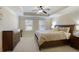 Spacious main bedroom featuring a ceiling fan, tray ceiling, and ample natural light at 8605 Gladden Ln, Suwanee, GA 30024