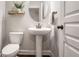 Stylish powder room features a pedestal sink, round mirror, and decorative accents at 8605 Gladden Ln, Suwanee, GA 30024