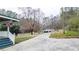 View of the driveway leading to a white building, surrounded by trees at 10 Creek Se Dr, Cartersville, GA 30121