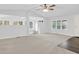 Sunlit living space with carpet flooring, a ceiling fan, and a wide opening leading to other living areas at 10 Creek Se Dr, Cartersville, GA 30121