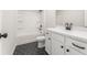 Bathroom features a shower-tub combo, black hexagonal tiles, and white cabinets with modern pulls at 2719 Byess Ct, Marietta, GA 30064