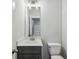 Well-lit powder room featuring a vanity with gray cabinets and modern lighting fixture at 3158 Stonegate Sw Dr, Atlanta, GA 30331