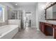 Bathroom showcasing a tub, tiled shower, double vanity, and neutral color palette at 4525 Hopewell Manor Dr, Cumming, GA 30028