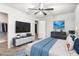 This bedroom has a ceiling fan, TV, and is virtually staged with modern furniture and blue accents at 4525 Hopewell Manor Dr, Cumming, GA 30028