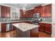 Modern kitchen with cherry wood cabinets, granite countertops, stainless steel appliances and kitchen island at 4525 Hopewell Manor Dr, Cumming, GA 30028