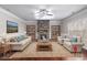 Cozy living room with a stone fireplace, wood floors, neutral paint, and built-in bookshelves at 4525 Hopewell Manor Dr, Cumming, GA 30028