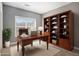 Home office featuring a large wooden desk, bookshelves, and a window for natural light at 4525 Hopewell Manor Dr, Cumming, GA 30028