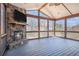 Enclosed screened porch with a stone fireplace, wooden beams, and a scenic view at 4525 Hopewell Manor Dr, Cumming, GA 30028