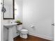Bright half bathroom with a pedestal sink, framed mirror, and hardwood flooring at 270 17Th Nw St # 2601, Atlanta, GA 30363