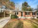 Charming brick home featuring a covered carport and a well-maintained front yard with mature trees at 4679 Bartlett Rd, Forest Park, GA 30297