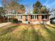 Charming brick home featuring a covered carport and a well-maintained front yard with mature trees at 4679 Bartlett Rd, Forest Park, GA 30297