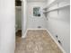 Laundry room with updated flooring, storage shelving, and a bright window at 4679 Bartlett Rd, Forest Park, GA 30297