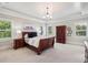 Comfortable primary bedroom featuring tray ceiling, bedside tables, and natural light from windows at 765 Hembree Rd, Alpharetta, GA 30076