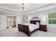 Comfortable bedroom featuring tray ceiling, bedside tables, and natural light from windows at 765 Hembree Rd, Alpharetta, GA 30076