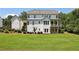 Rear exterior of the home showcases a spacious yard and a charming covered porch at 765 Hembree Rd, Alpharetta, GA 30076