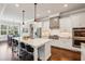 Bright, open kitchen with white cabinets, large island, stainless steel appliances, and hardwood floors at 765 Hembree Rd, Alpharetta, GA 30076
