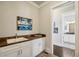 Bright mudroom with white cabinets, wood countertop, wall art, and hardwood flooring at 765 Hembree Rd, Alpharetta, GA 30076
