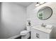 Bright powder room with shiplap accent wall, modern vanity, and round mirror, offering a stylish and functional space at 765 Hembree Rd, Alpharetta, GA 30076