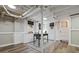 Finished basement space with exposed pipes, painted white brick, and wood-look flooring at 28 Peachtree Hills Ne Ave, Atlanta, GA 30305