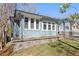 Side angle view of a blue brick house with a stone retaining wall and pergola-covered front porch at 28 Peachtree Hills Ne Ave, Atlanta, GA 30305