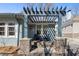 Inviting front porch with a pergola, stylish seating, and stone pillars on a blue brick home at 28 Peachtree Hills Ne Ave, Atlanta, GA 30305