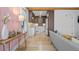 Open living room featuring hardwood floors, unique pink panel wall, and a view into the modern kitchen at 28 Peachtree Hills Ne Ave, Atlanta, GA 30305