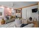 Open-concept living room with pink accent wall and kitchen view creates a modern and inviting space at 28 Peachtree Hills Ne Ave, Atlanta, GA 30305