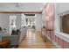 Spacious living room with pink accent wall and sunroom view provides a modern and stylish living space at 28 Peachtree Hills Ne Ave, Atlanta, GA 30305